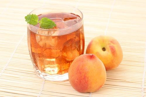 В прозрачном стакане чая из персиков со льдом